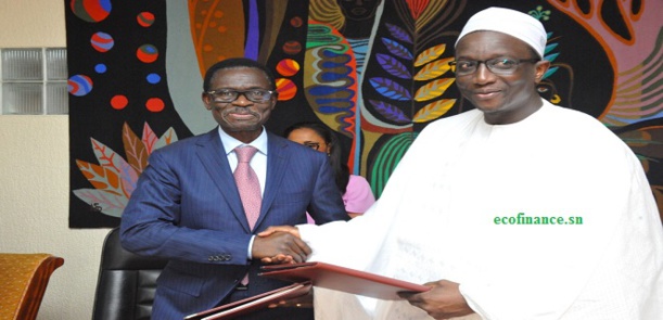 Poignée de main entre Adovelande, président Boad en costume et le ministre Amadou Bâ après la signature de l'accord de prêt pour le financement boucle du Boudier.