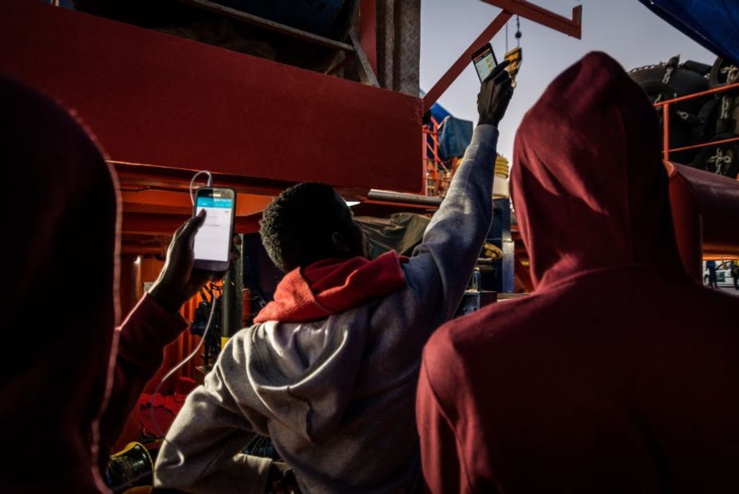 Les migrants essaient d'avoir un réseau sur leurs téléphones à Algésiras, en Espagne. Photo par Ignacio Marin / Agence Anadolu / Getty Images
