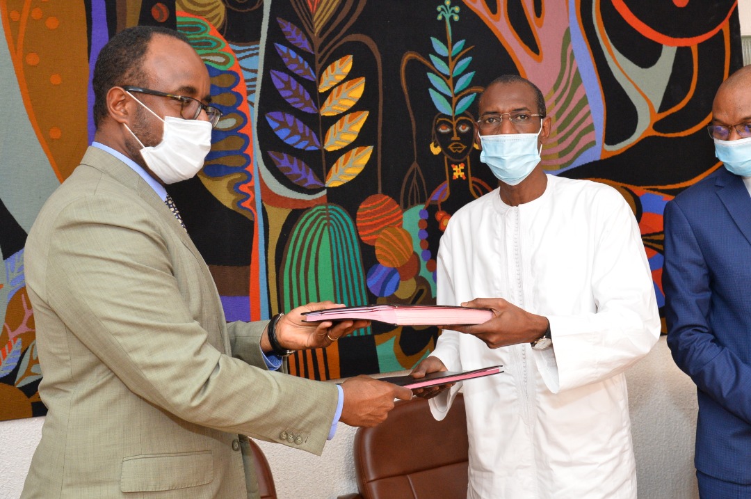 Echange de document entre Nathan Belete, directeur des Operations de la Banque mondiale pour le Sénégal à gauche et Abdoulaye Daouda Dialllo, ministre sénégalais des Finances et du Budget.