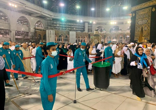Des travailleurs sanitaires portant des masques protecteurs nettoient le complexe de la Grande Mosquée de La Mecque le 27 février 2020.