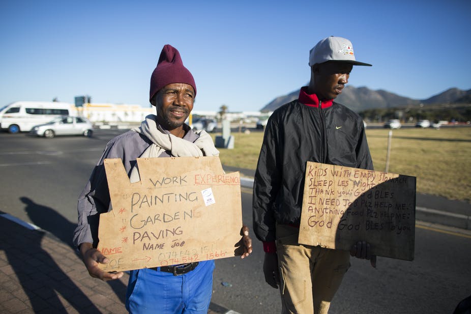 Deux chômeurs vantent des emplois occasionnels dans une rue du Cap. EFE-EPA / Nic Bothma