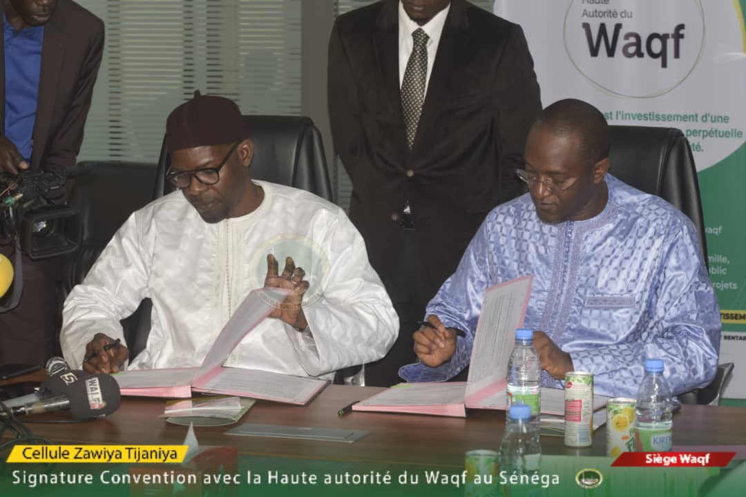 A droite, Monsieur Racine Bâ, Directeur général de la Haute Autorité du Waqf au Sénégal en compagnie de Serigne Abdoul Hamid Sy, Coordinateur de la Cellule Zawiyya Tijjâne procédant à la signature de la Convention de partenariat visant à promouvoir l'inclusion sociale et le Waqf.