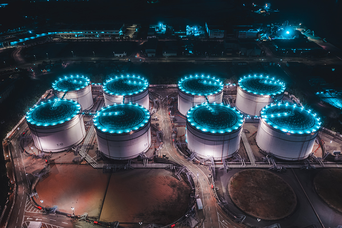 Les réservoirs de stockage de pétrole sont éclairés la nuit.  Chunyip Wong / Getty Images﻿